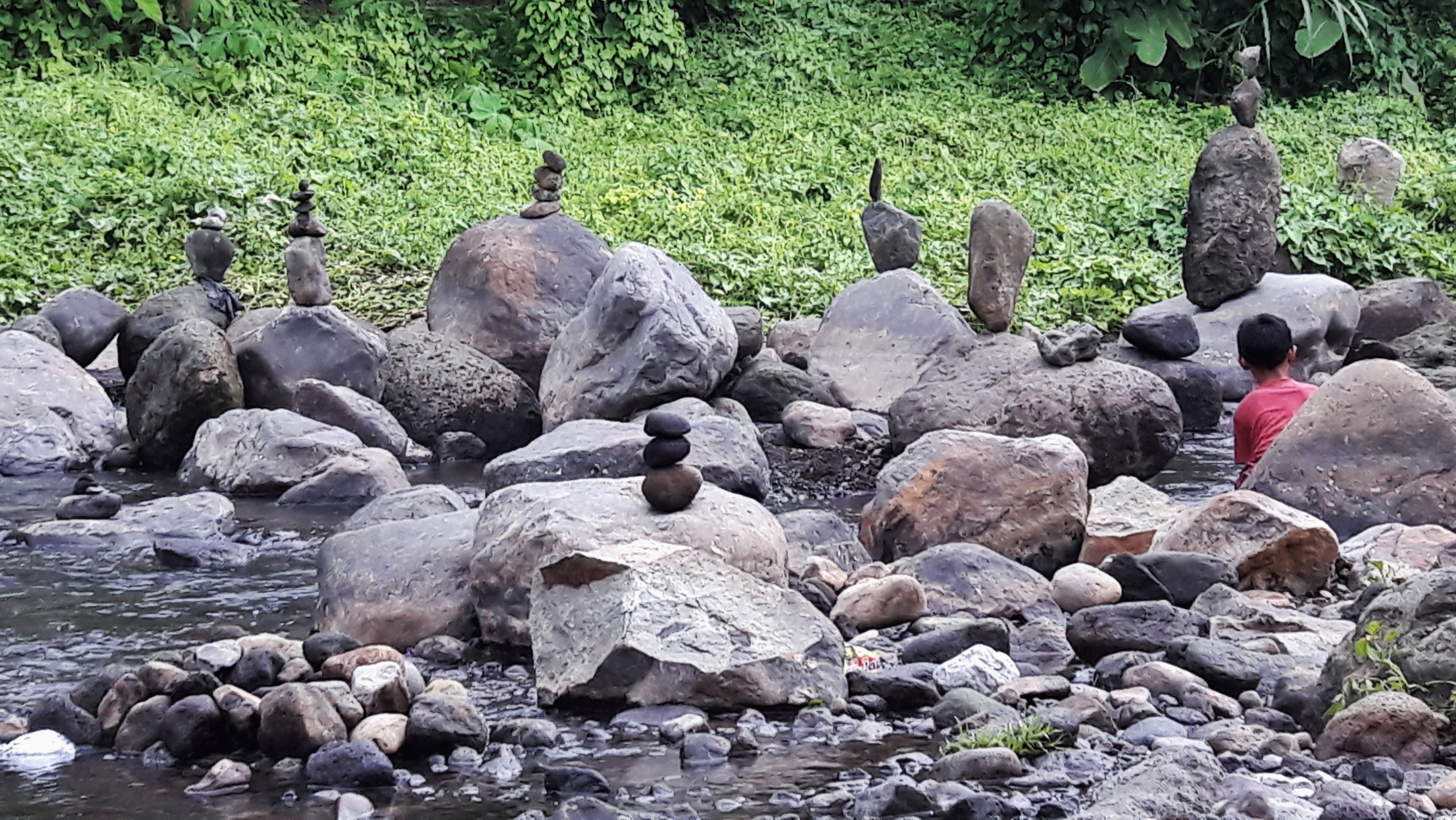 Pemandangan seni menata batu di sepanjang sungai oleh Annissa Saputri