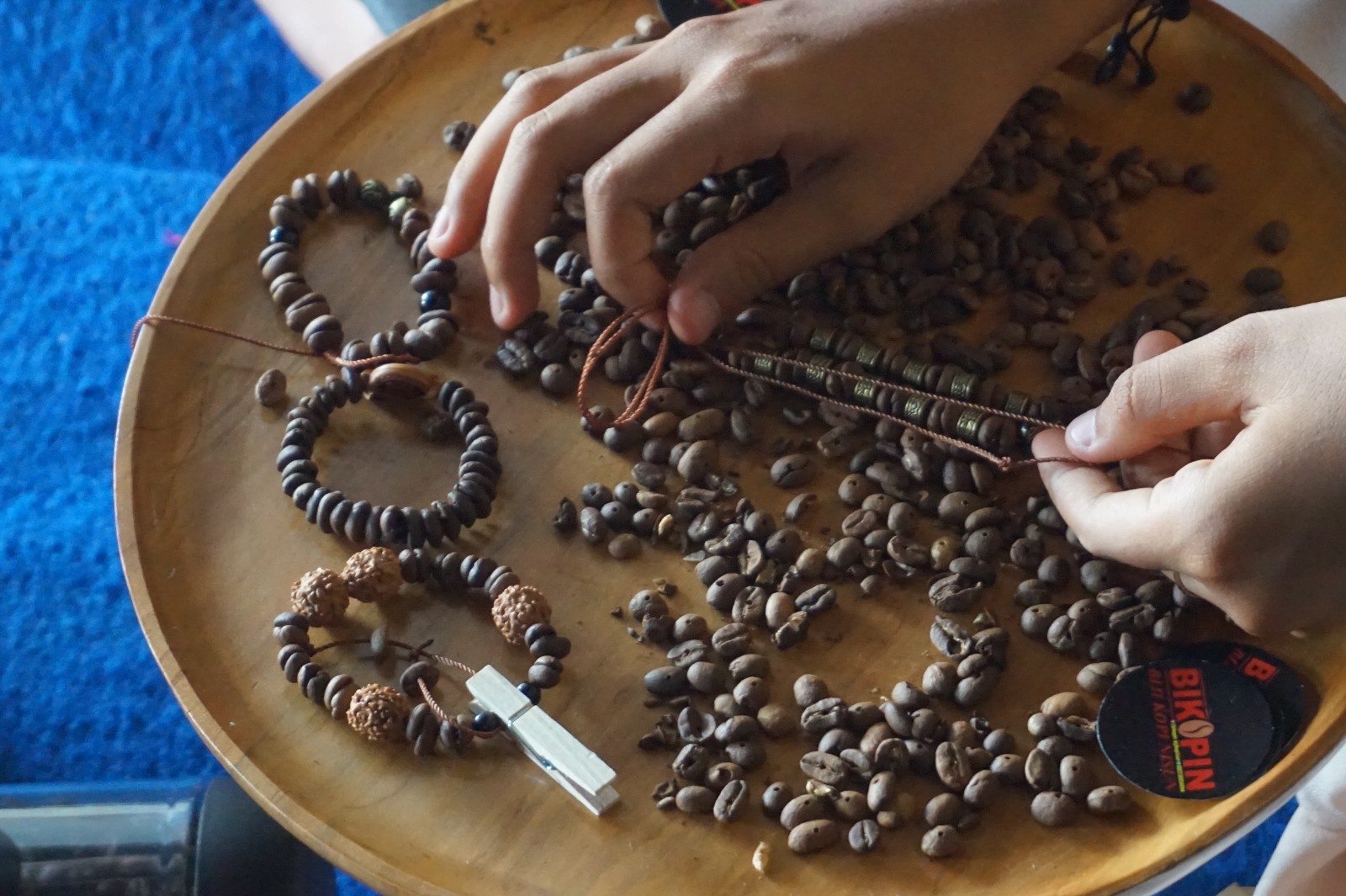 Proses pembuatan gelang dari biji kopi di Desa Singolatren Kecamatan Singojuruh Banyuwangi / Travelingyuk / Ismiraa